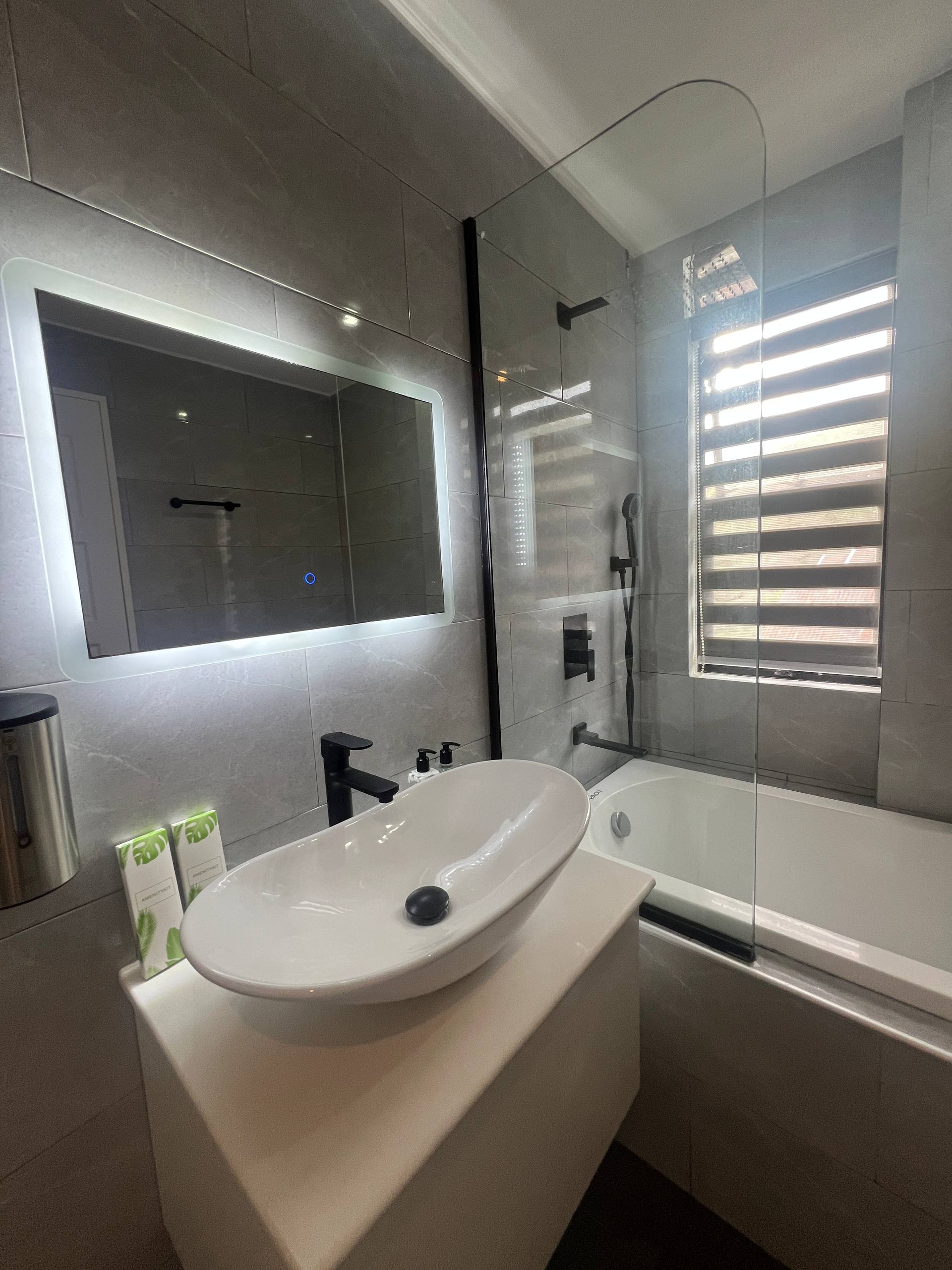 En-suite vanity with vessel sink, LED mirror and black faucet