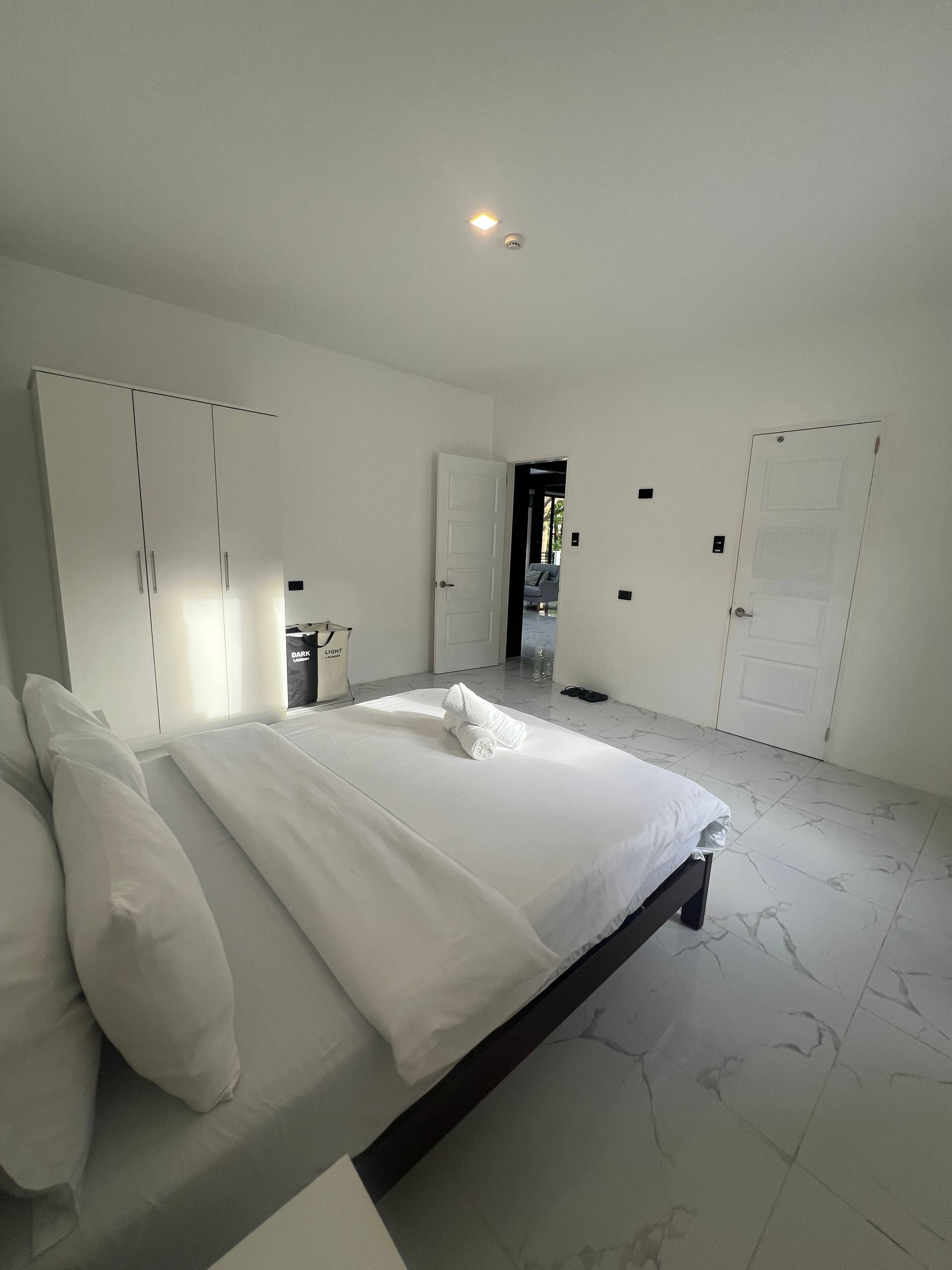 Bedroom 5 from foot of bed with open door to living area