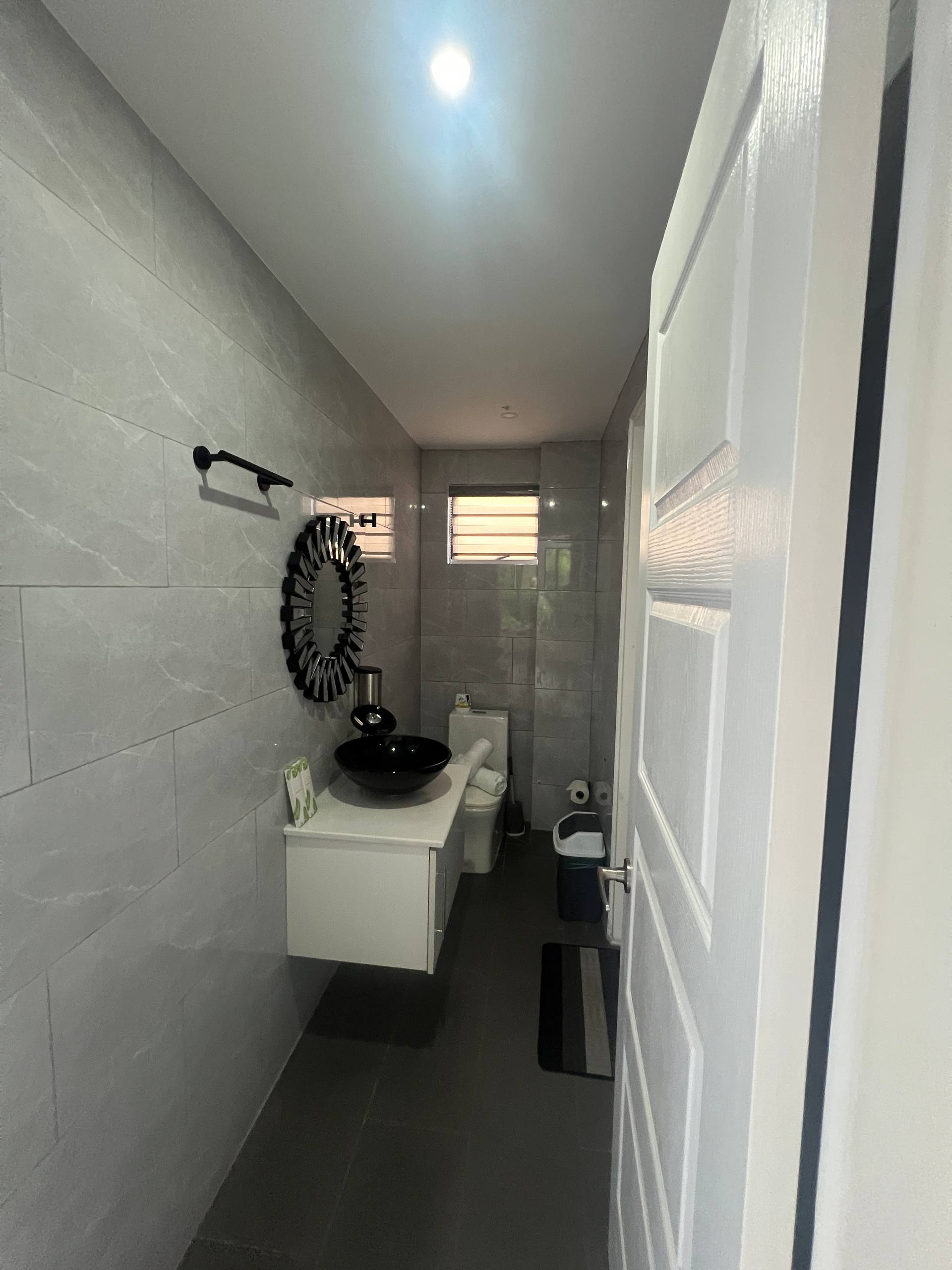 En-suite narrow view with towel bar, mirror and toilet